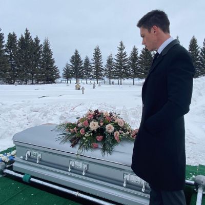 Photo of Tanner Novlan standing still in front of his grandma Bea's grave.